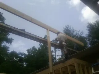Carpenter setting a ridge beam over a new addition frame — Ice Dam Removal by Roofing Brothers in Colchester